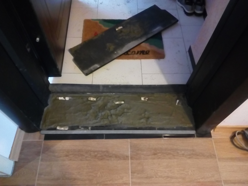 Запълване на кухината между металните шини на касата на вратата, преди поставянето на прага