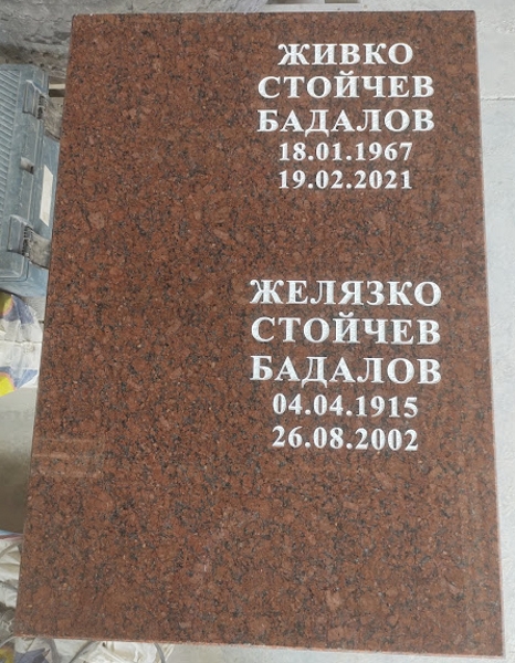 Плоча от червен гранит, с две имена, с вдълбани букви, боядисани бели Плоча от червен гранит, с две имена, с вдълбани букви, боядисани бели