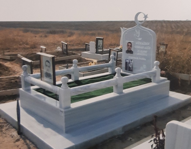 Паметник с размери 100/80/6 см, с порцеланови снимки, вдълбани надписи, гравирани гълъб и роза, парапет от струговани ръкохватки, правоъгълни заоблени бази с топки отгоре, постамент 100/20/6 см, висок облицован бордюр, мраморна пътека, бетонна основа, изглед отдясно