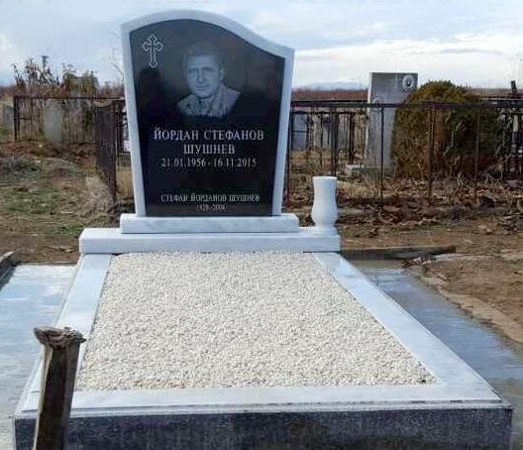 Паметник от мрамор Тилос, модел Вълна, със залепена черна гранитна плоча, с гравиран портрет, кръст и надписи, два постамента, кръгла мраморна ваза, бордюр от мозаечна рамка със залепини мраморни плочи отгоре, гробът е покрит с бяла мозайка, с циментова пътека.