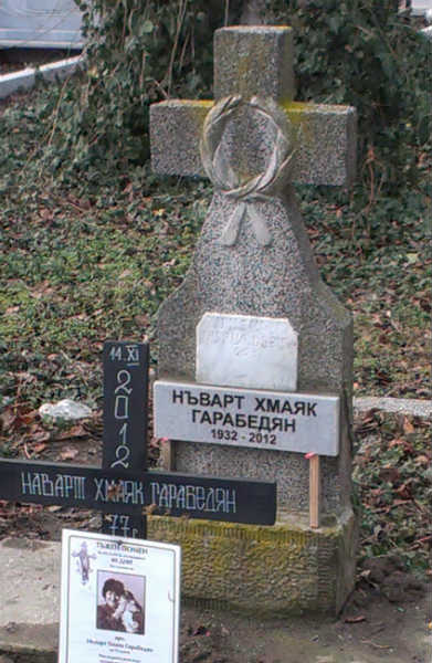 Допълнителна плочка с надпис, монтирана на стар паметник. Надписът е с тесен прав шрифт, вдълбани черни букви на сив мрамор