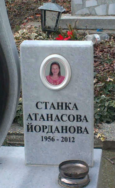 Допълнителна плочка с надпис и цветна порцеланова снимка, монтирана на стар паметник.Надписът е с тесен шрифт със серифи, вдълбани черни букви на сив мрамор. Плочката е с дебелина 6 см