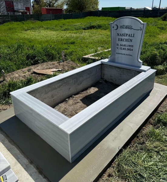 Monument musulman cu semilună și stea, inscripție cu litere negre sculptate, ornamente, piedestal, bordură înaltă cu gresie, alee de beton, bază de beton
